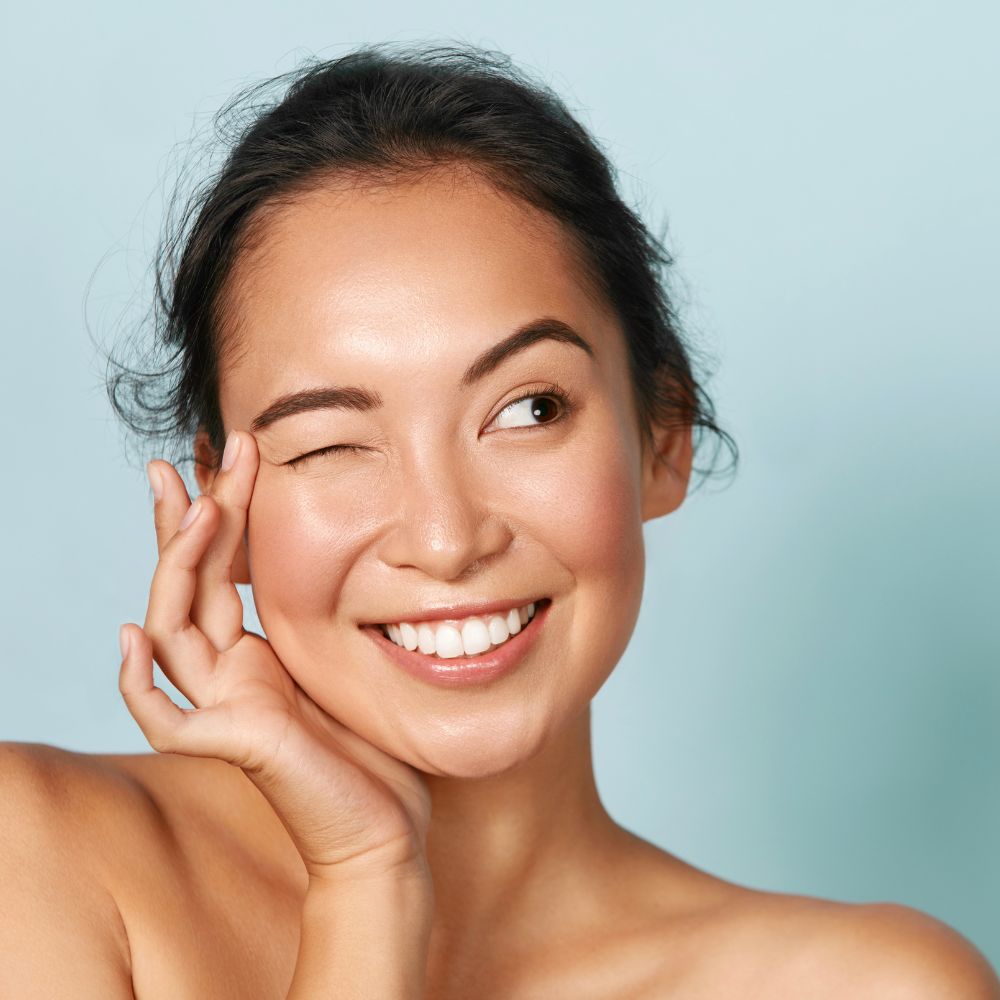 Asian woman with good skin smiling and looking to the right