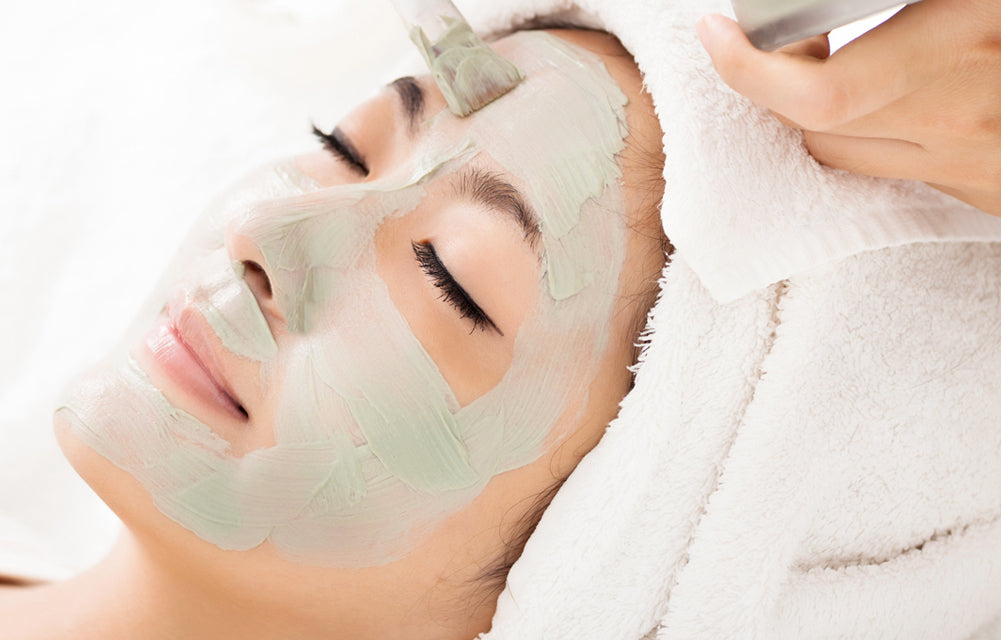 asian woman receiving facial mask